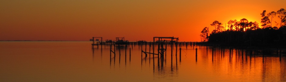 Orange sunset over calm water and docks on the Florida Panhandle